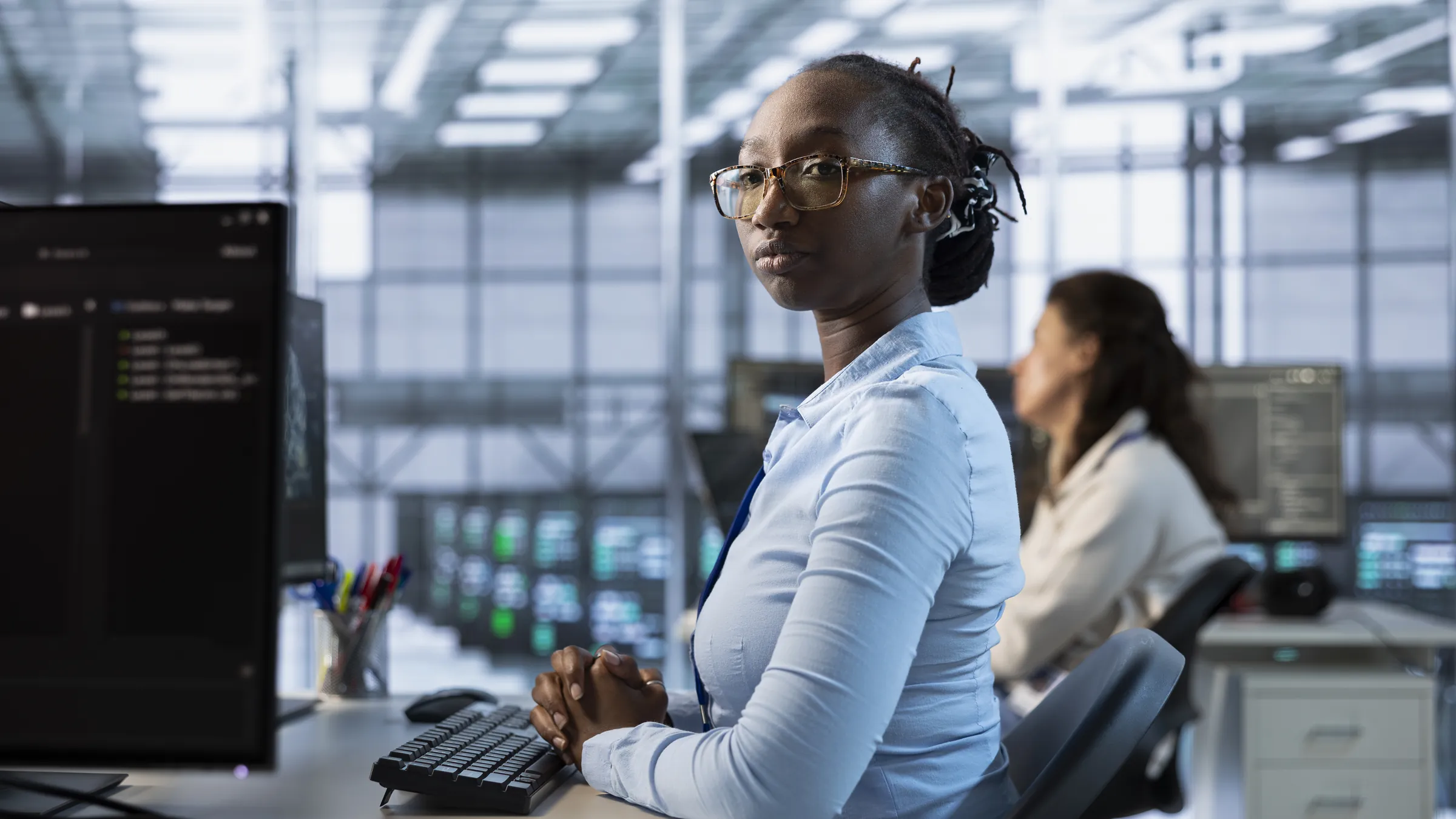An engineer at her workstation in a server room